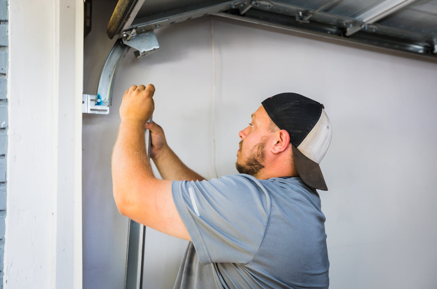 Expert technician doing garage door track repair service.